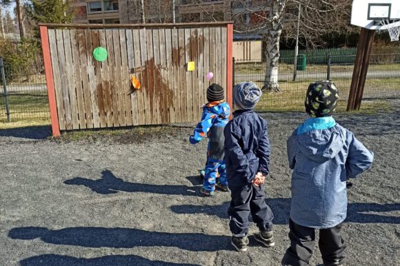 lapset heittää vesi-ilmapalloja maalitauluun