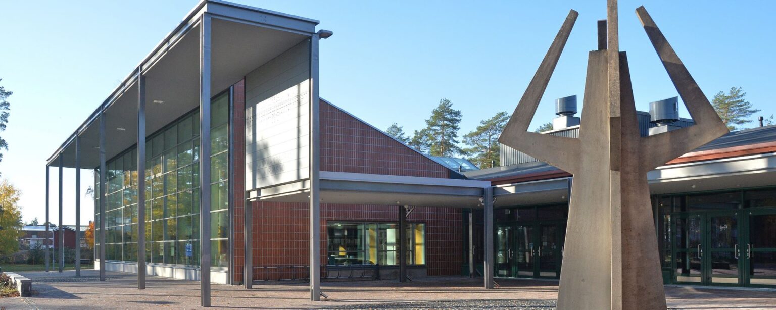 keväinen julkisivukuva kirjastosta, tadeteos etualalla