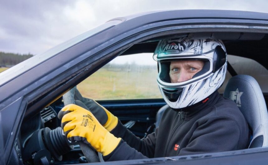 Marko istuu autossa kypärä päässään.
