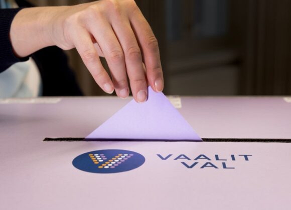Lähikuva äänestyslipun tiputtamisesta vaaliuurnaan.