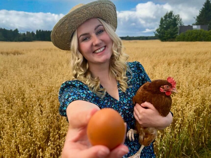 Nainen pellolla kana sylissä