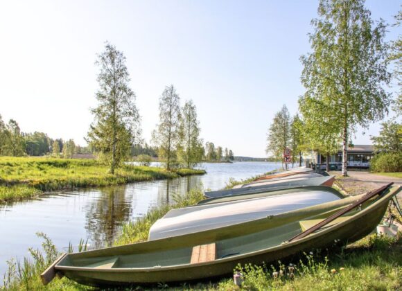 Veneitä Rivieran venepaikoilla, taustalla kesäinen järvimaisema.