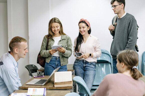 opiskelijat opiskelijoita juttelemassa pöydän ympärillä