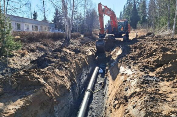 Kaivinkone kaivaa ojaa runkovesijohdolle.