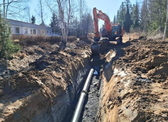 Kaivinkone kaivaa ojaa runkovesijohdolle.